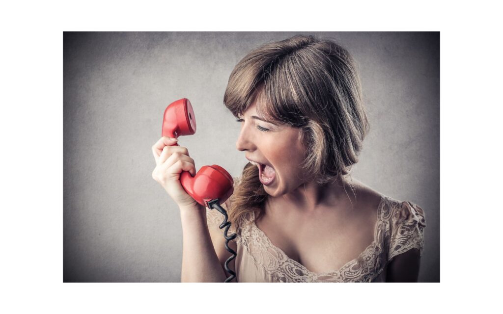 Frau ist voller Wut, schreit in einen Telefonhörer
